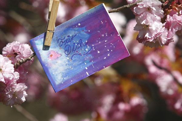 Self painted greeting card hanging in tree