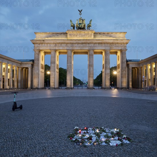 Brandenburg Gate with silent protest and parked e-scooter on Pariser Platz in the early morning
