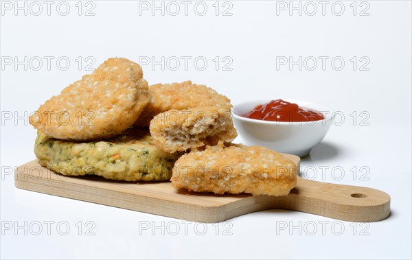Meat substitute on wooden board and tray with ketchup