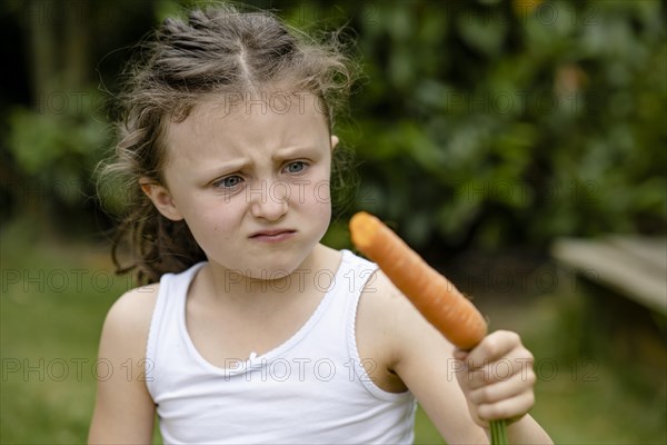 Girl with carrot turns up her nose