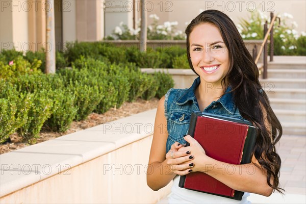 mixed-race young girl student with school books on campus