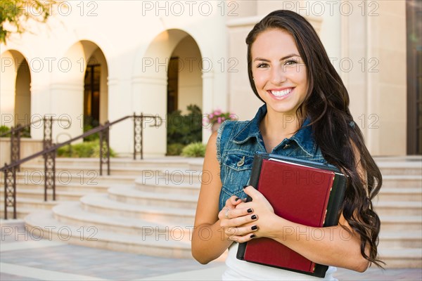 mixed-race young girl student with school books on campus