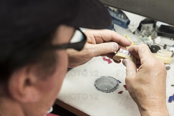 Male dental technician working on A 3D printed mold for tooth implants in the lab