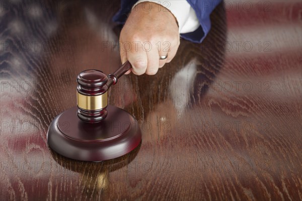 Judge slams his gavel and american flag table reflection
