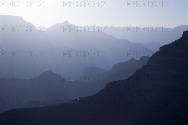 Scenic layers of the grand canyon in the early morning with hikers cabin roof shining in the lower middle
