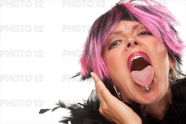 Pink and black haired girl sticking her pierced tongue out isolated on a white background