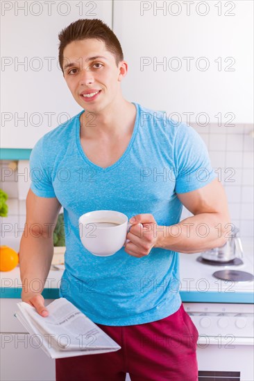 Reading newspaper man reading in kitchen morning laugh in germany