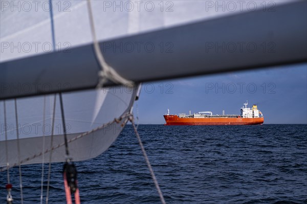 Sailing on the North Sea near Holland with freighter at anchor