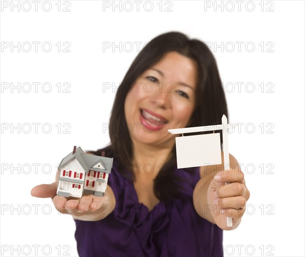 Multiethnic woman holding small blank real estate sign and house in hand isolated on white background