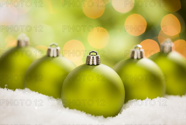Beautiful matt green christmas ornaments on snow flakes over an abstract background with room for your own text
