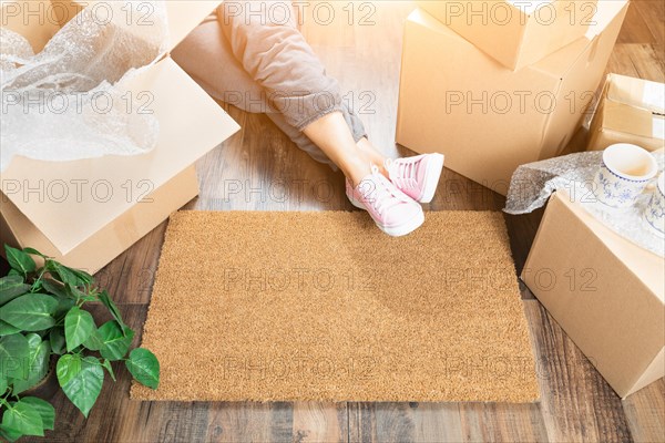 Woman wearing sweats relaxing near home sweet home welcome mat