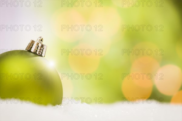 Beautiful matt green christmas ornaments on snow flakes over an abstract background with room for your own text