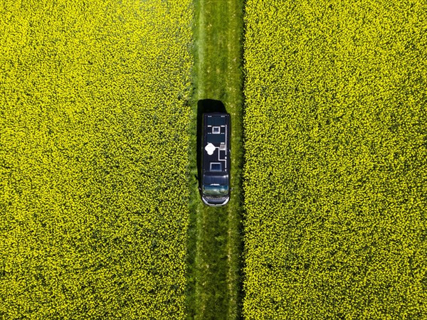 Drone shot of a camper van in a rape field