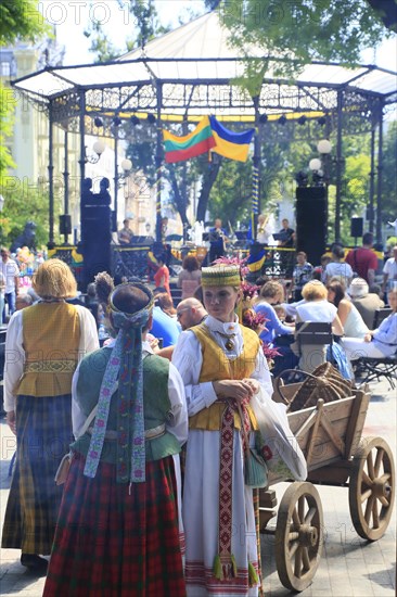 Folk group in traditional costumes in front of the music pavilion in the city garden