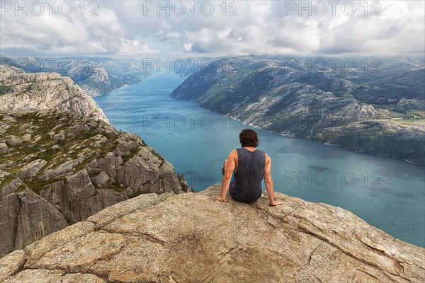 Hiker sitting on rock pulpit Preikestolen