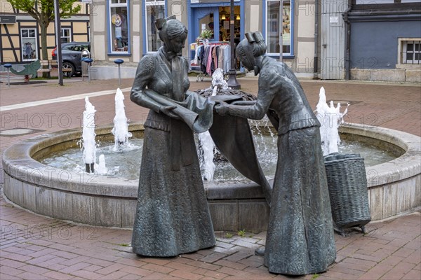 Sculpture of two linen weavers at the fountain in front of the town hall in Luechow