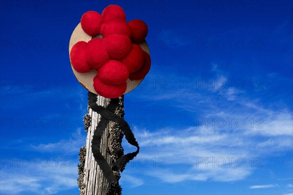 Original Black Forest Bollen hat on wooden post in front of blue sky