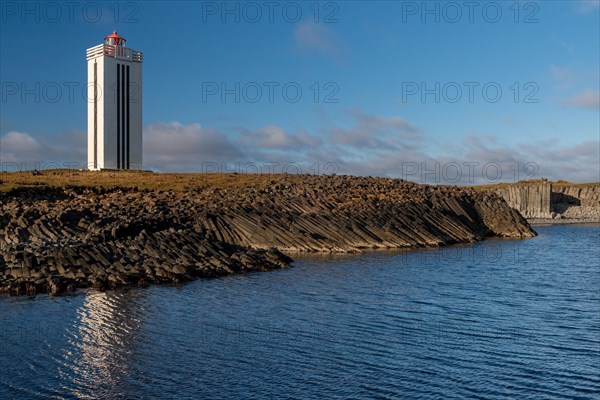Lighthouse and coastal landscape with basalt formations and basalt cliff
