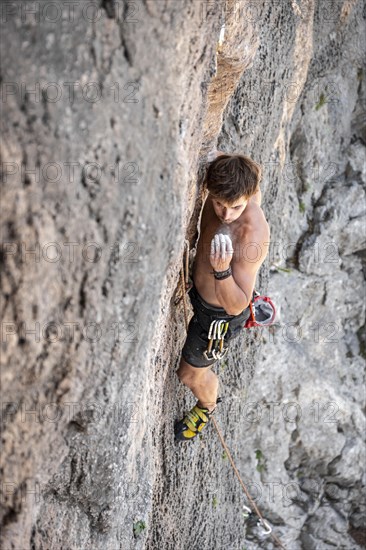 Young man climbing on a rock face