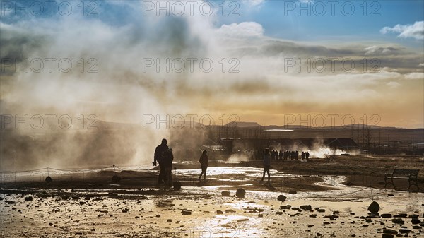 Visitors between steaming springs in the high temperature area Haukadalur
