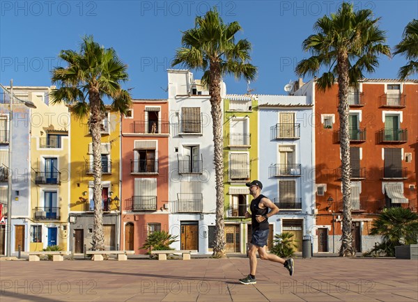 Runner in front of Colorful beachfront houses