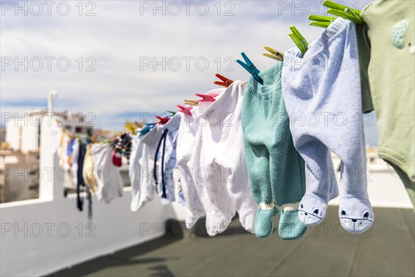 A lot of baby clothes drying on the roof in the city