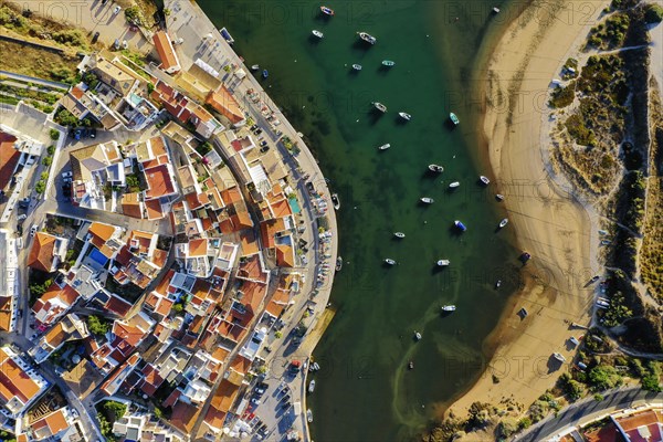 Aerial cityscape of white washed Ferragudo by Arade River