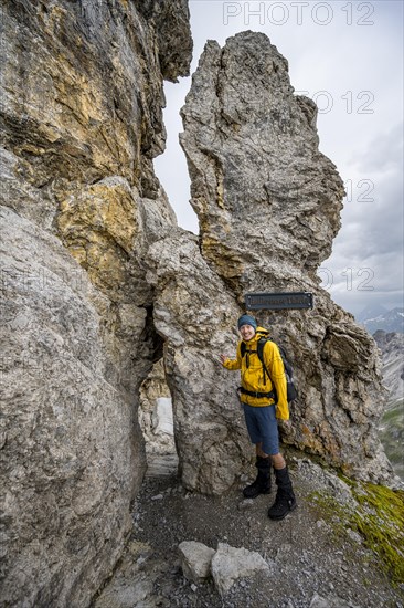 Hiker at rock formation with rock hole