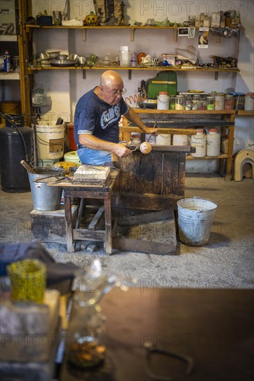 Master glassblower working hot glass
