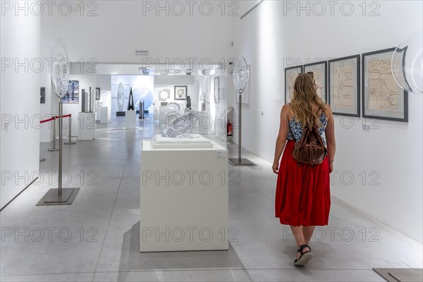 Young woman in the glass museum looking at hand-blown glass