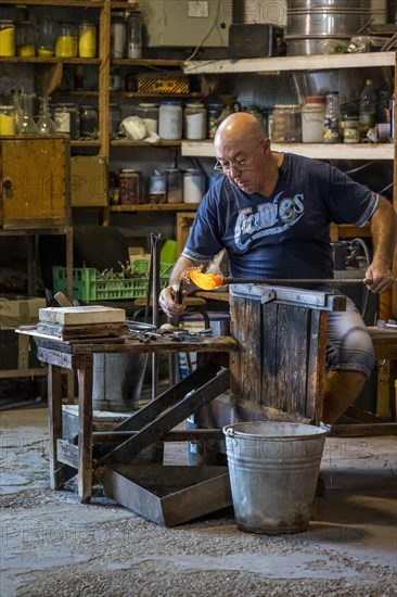 Master glassblower working hot glass