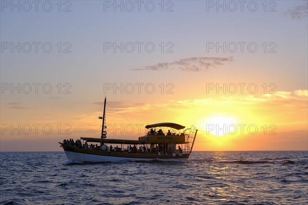 Tourist boat in the sea at sunset