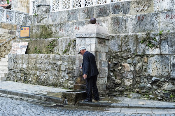Man washing his hands at the well