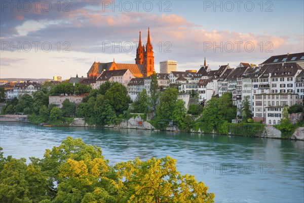 View of the Basel Cathedral in the middle of the old town of Basel with the turquoise Rhine River in the foreground
