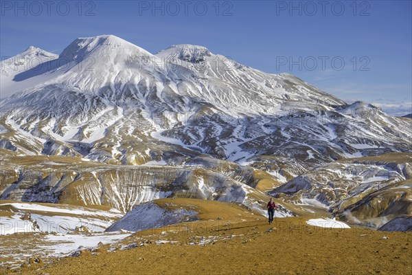 Woman in front of snowy mountains Fannborg and Snaekollur in the hot spring area Hveradalir