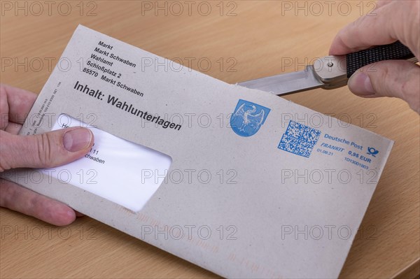 Man opens envelope with postal voting documents for the election of members of the German Bundestag on 26.09.2021