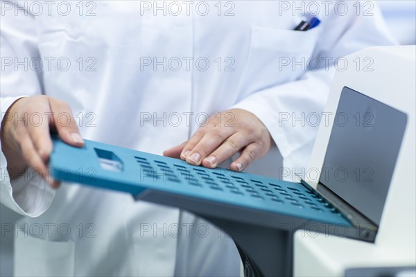Young laboratory assistant with sample working in a laboratory with laboratory equipment