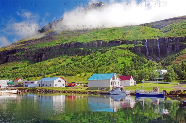 Boats and small houses reflected in the fjord