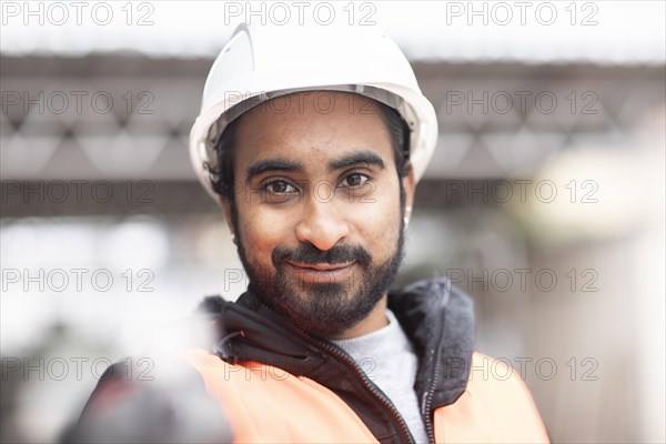 Technician with beard and helmet works in a workshop