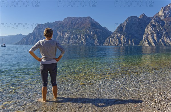 Hiker with footbath to cool down in Lake Garda
