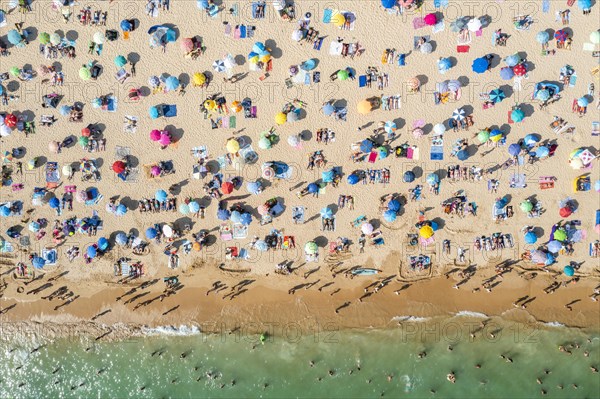 Drone shot of people enjoying the beach and the ocean