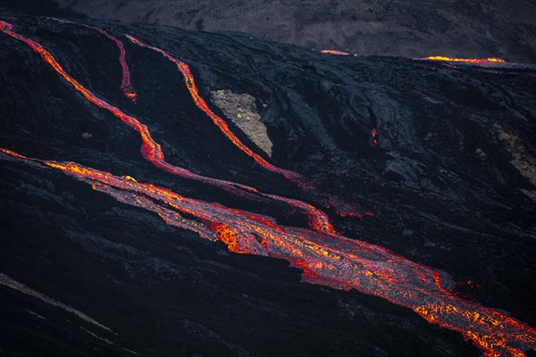 Erupting volcano with lava fountains and lava field