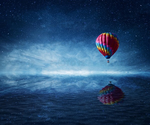 Hot air balloon flying over the a cold dark blue sea
