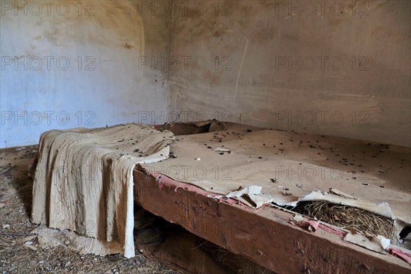Demolished bed frame with blanket and pigeon droppings
