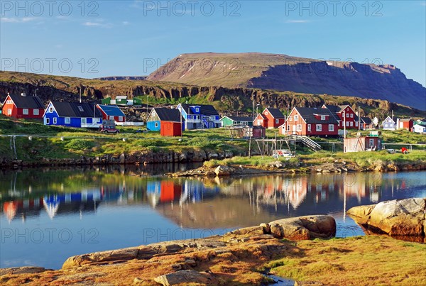Wooden houses reflected in a calm body of water