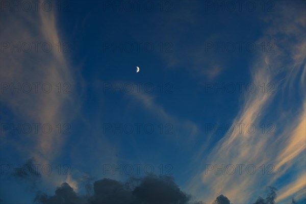 Evening sky with clouds and half moon