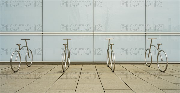 Design of aluminium bicycles in front of a bright plastic wall