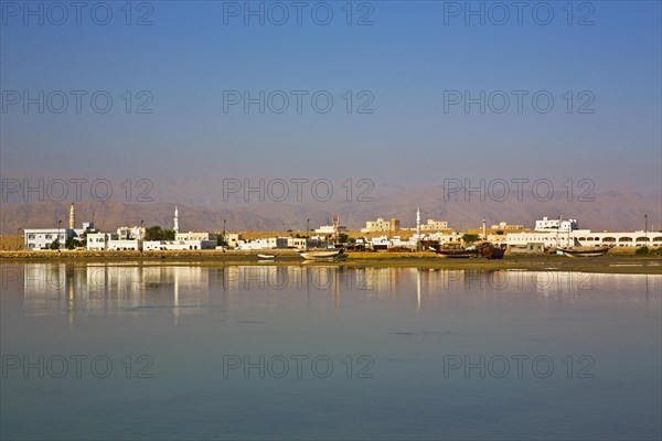 Trcoken-laid dhows against a city backdrop