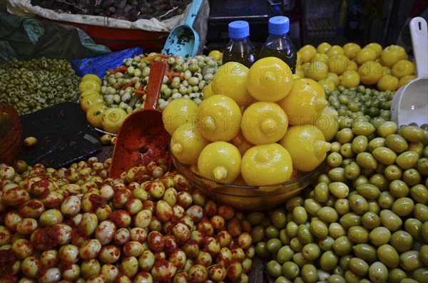 Bowl of Moroccan salted lemons on mountain with varieties of olives