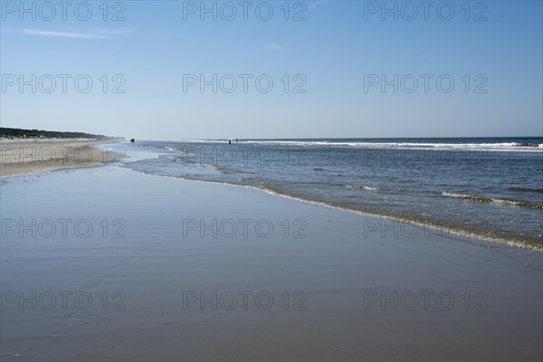 Long sandy beach with outgoing waves